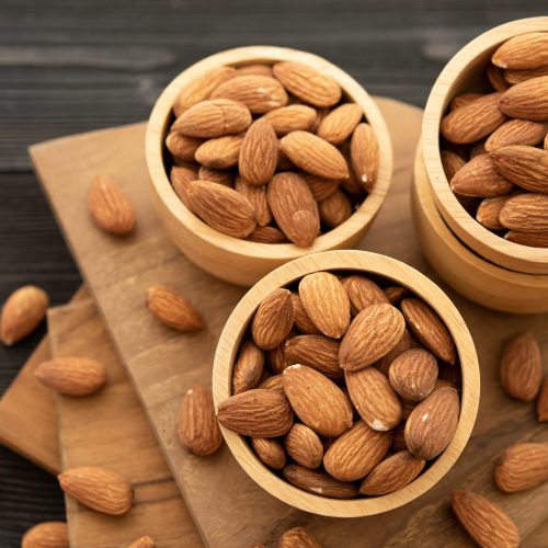 Bowl with almond on a wooden table. (selective focus; close-up shot)